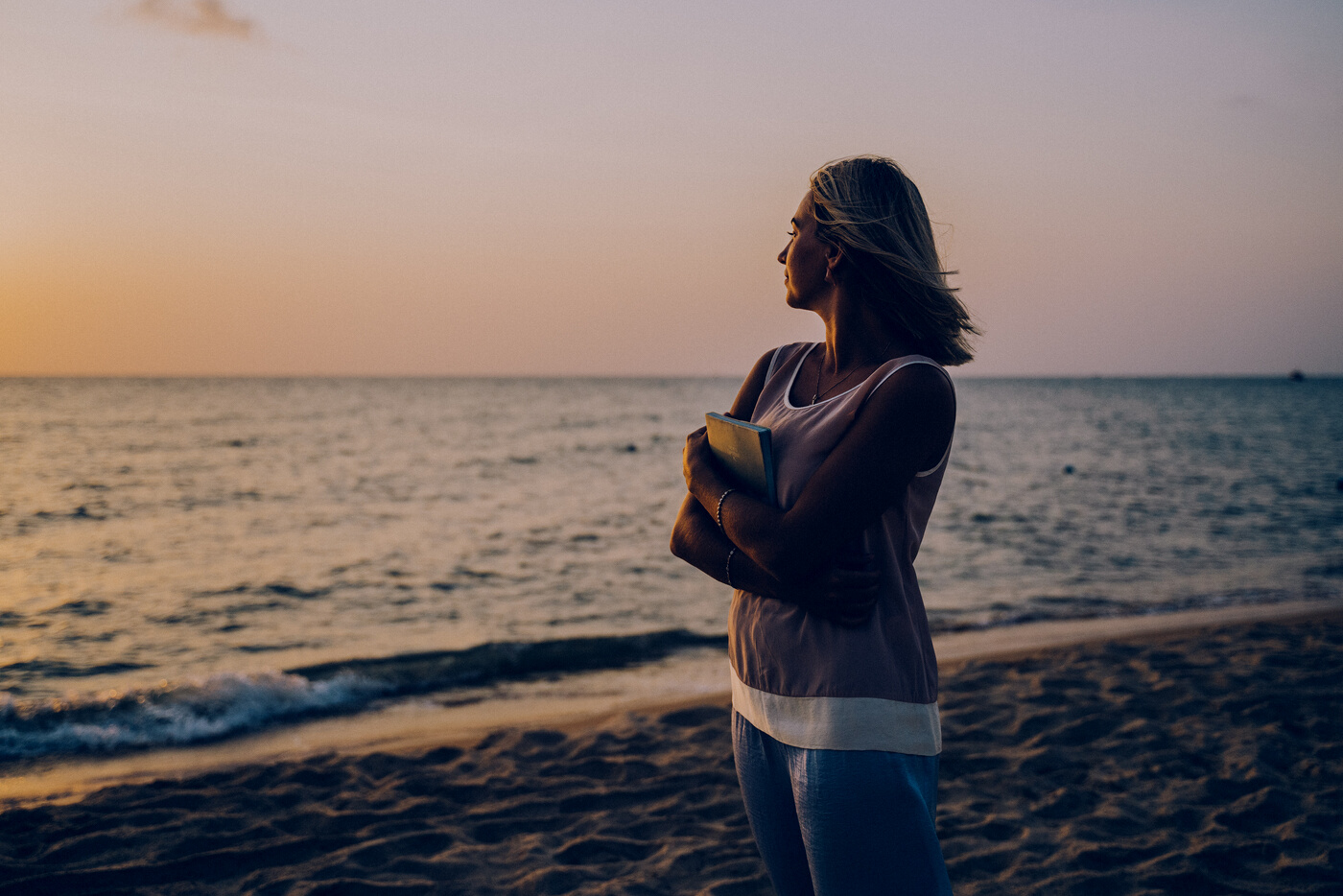 Woman Wearing Sleeveless Top Standing on the Beach during Sunset